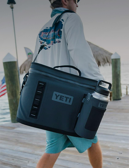 Person carrying a YETI cooler bag on a dock