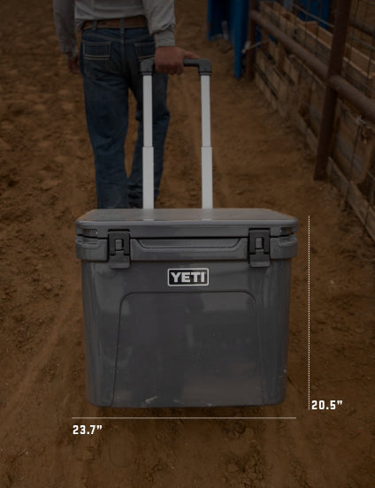 YETI cooler being pulled by a person in a dirt arena