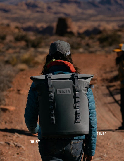 Person wearing a YETI cooler backpack in a desert setting