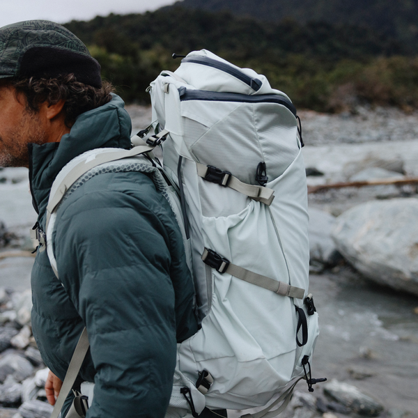 Person wearing a large hiking backpack on a rocky trail