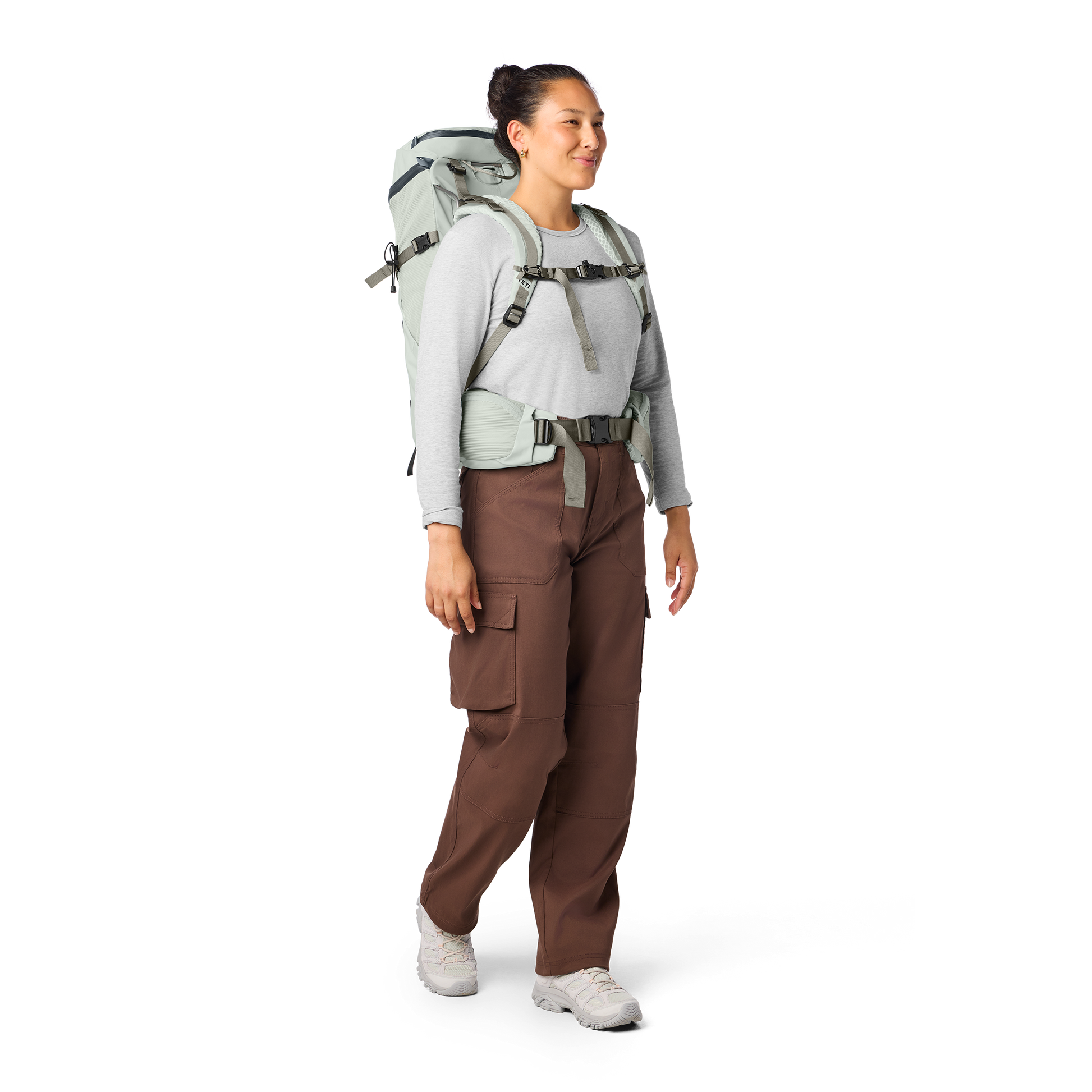 Person wearing a backpack and brown pants on a white background