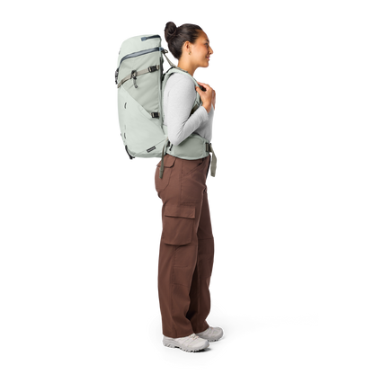 Person wearing a large white backpack on a white background