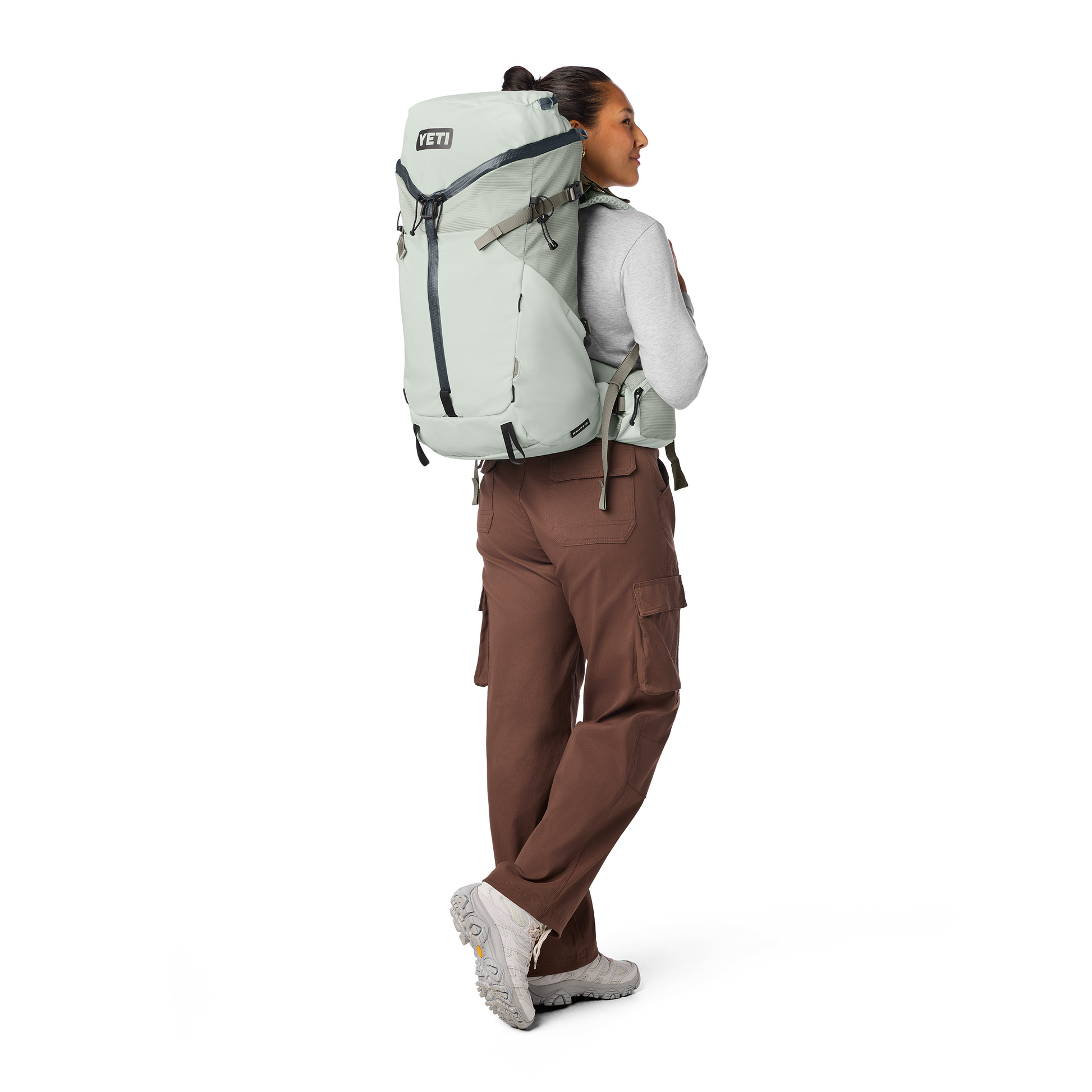 Person wearing a large white backpack with visible branding on a white background