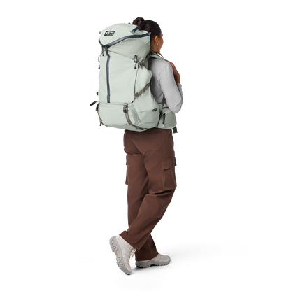 Person wearing a large backpack on a white background