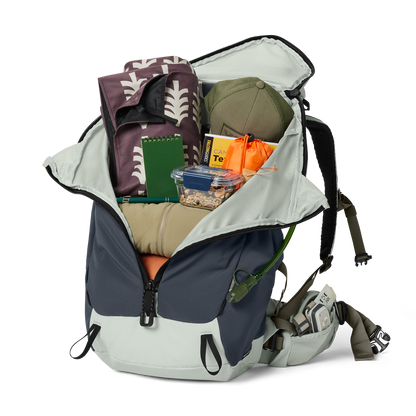 Backpack with various items including a hat, books, and snacks on a white background